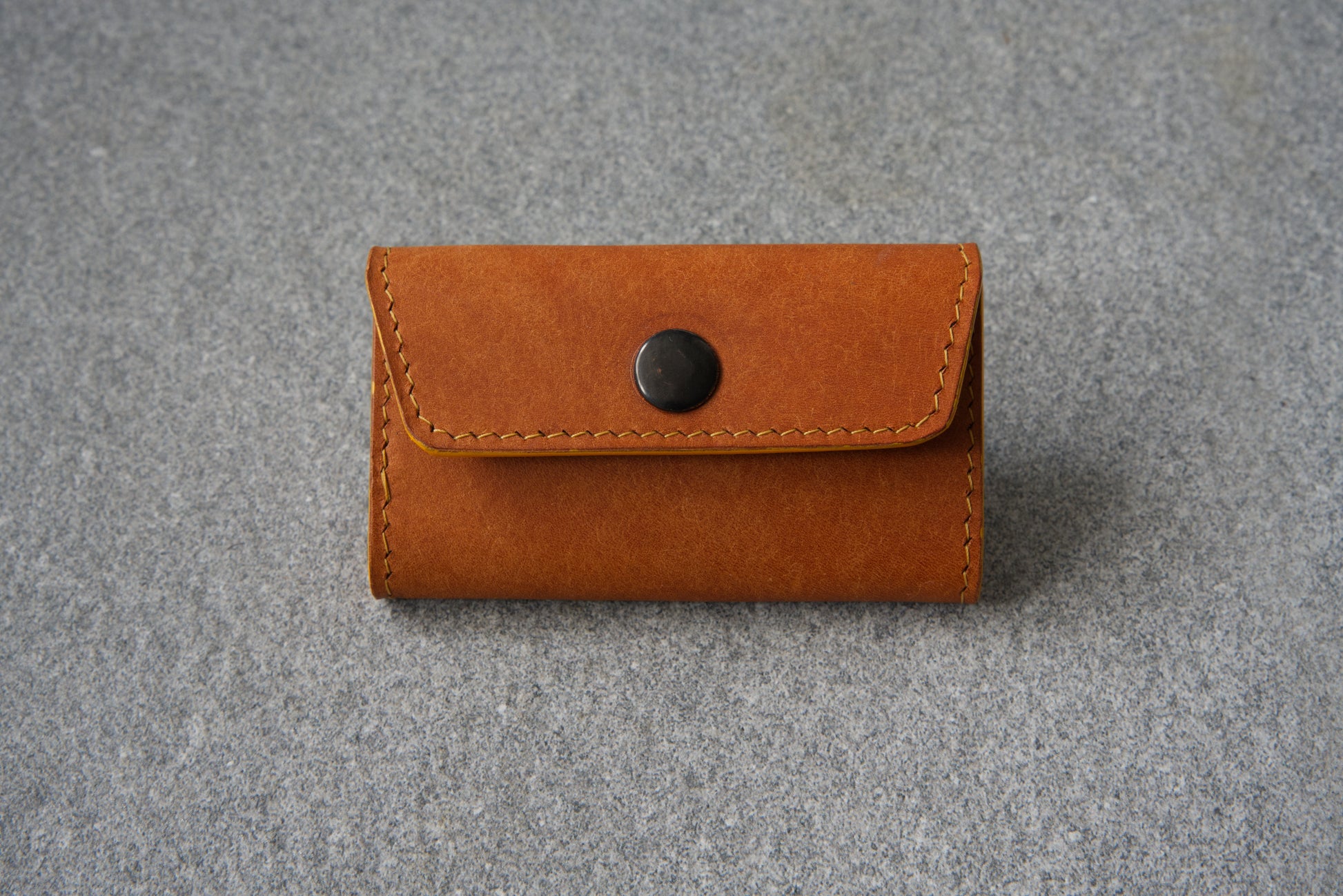 Memory mate - SD card holder in the orange (Olmo) variant in its folded form. Showing gun metal snap